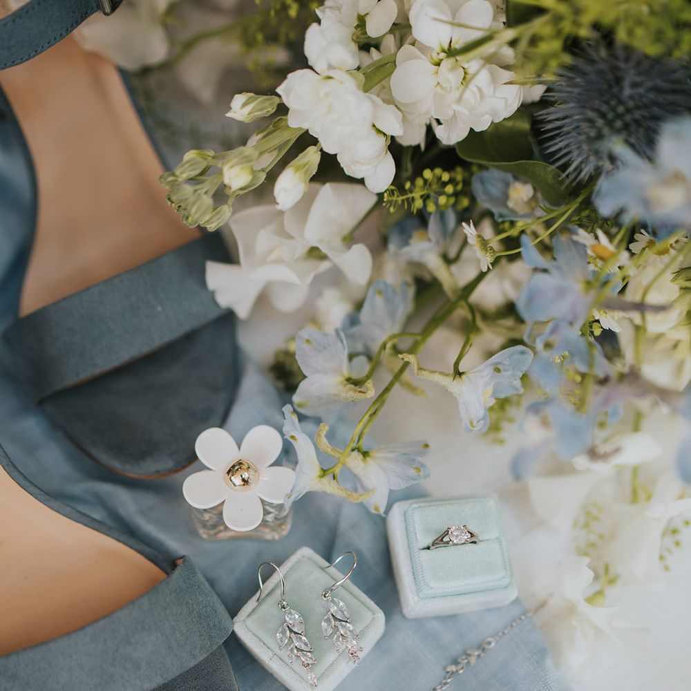 Blue suede wedding shoes with velvet jewellery boxes holding the ring and earrings with Marc Jacobs Daisy perfume wedding scent 