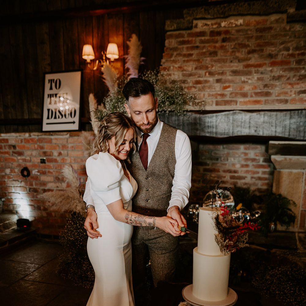 The newlyweds cute their two tier wedding cake 