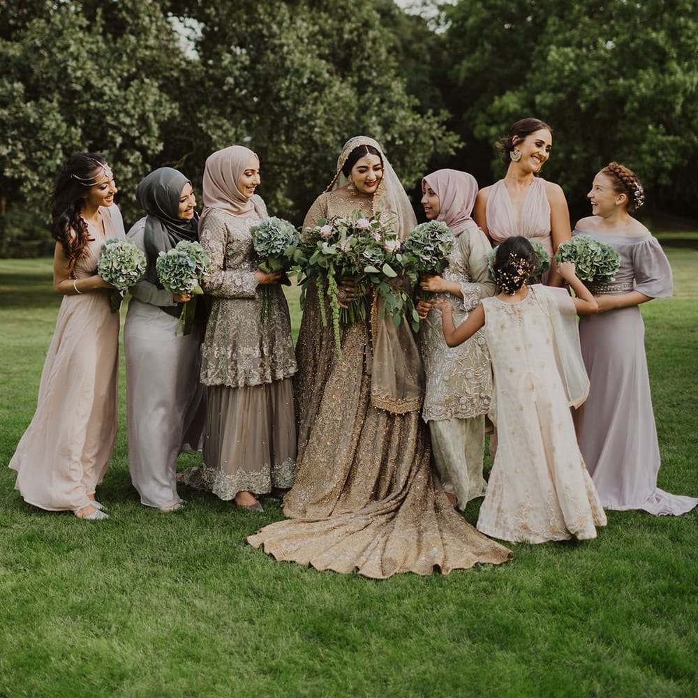 Bridal party portrait with bridesmaids in pastel dresses and saris' for multicultural wedding 