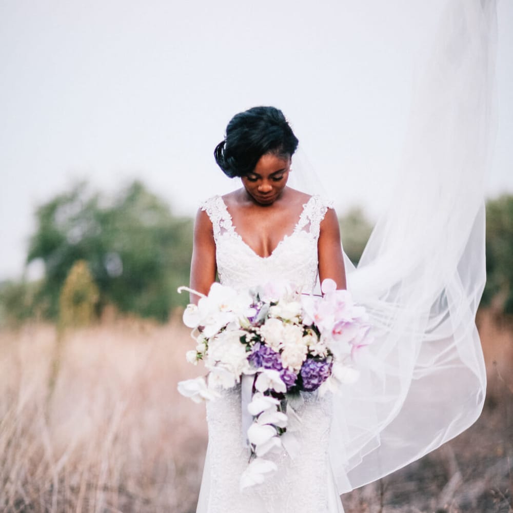 Beautiful bridal shot of newly wed bride holding bouquet wearing a lace wedding dress for Italian wedding