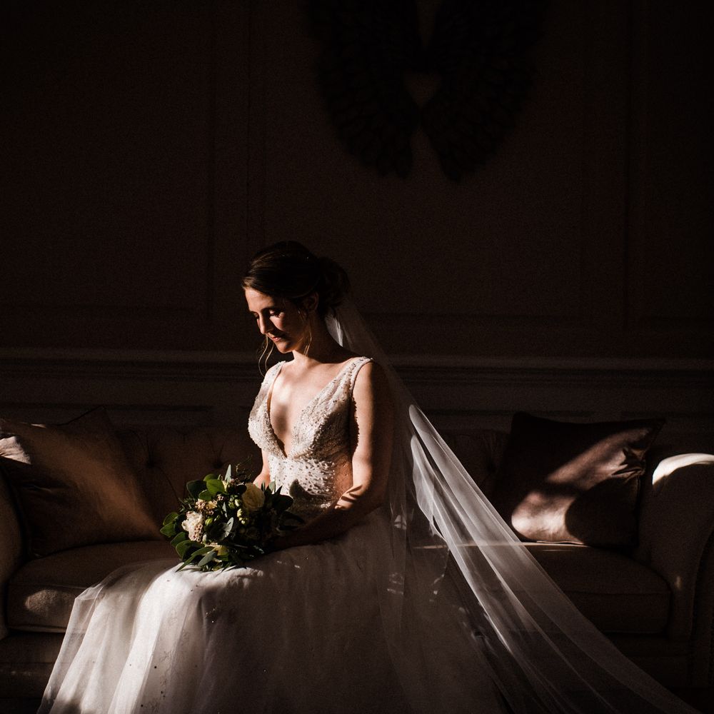 Bride sits in the shadows on the morning of her wedding