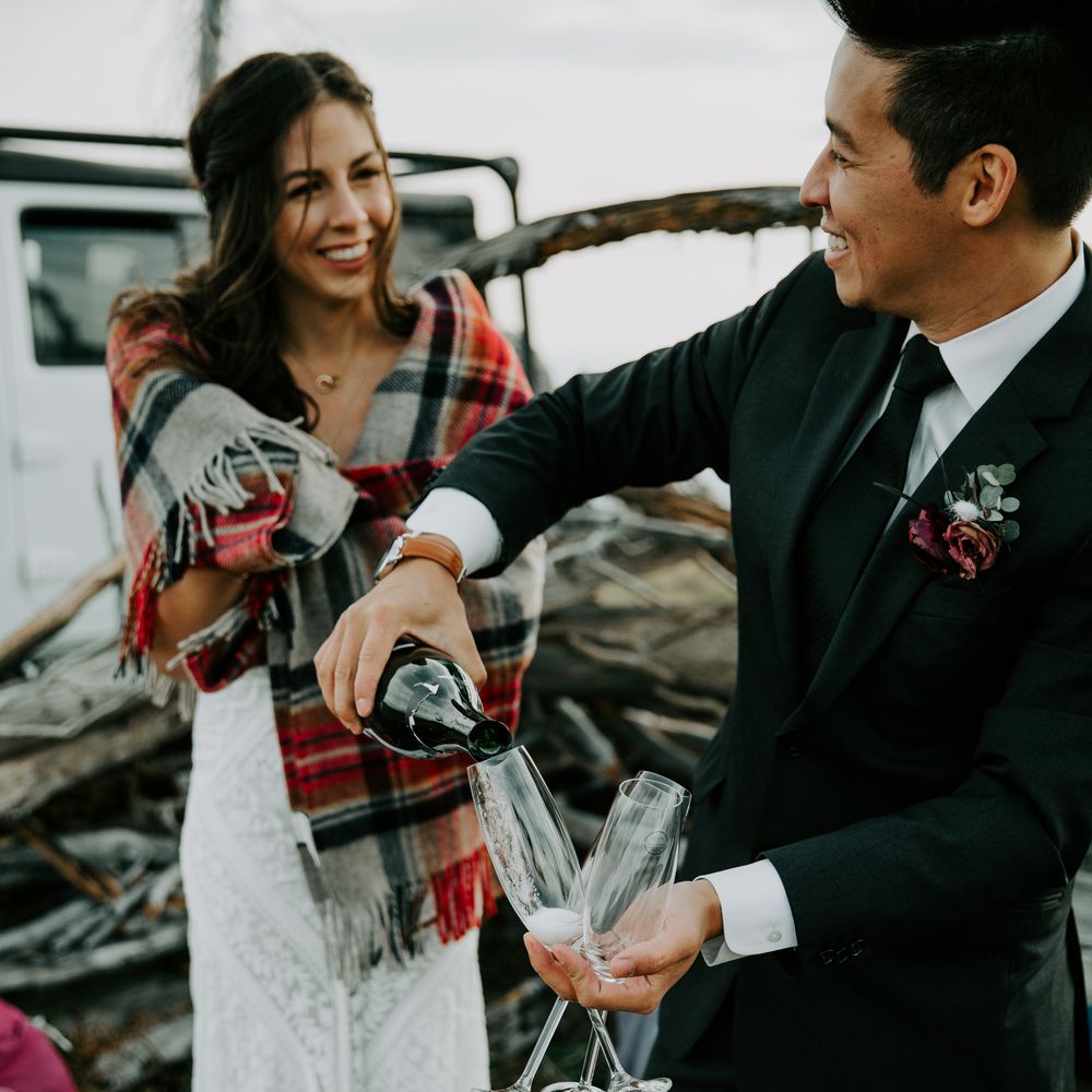 Groom pours champagne for guests and bride