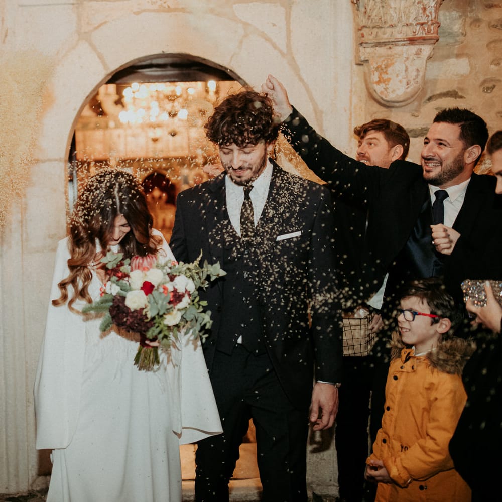 The bride and groom having confetti thrown over them as thye leave their ceremony