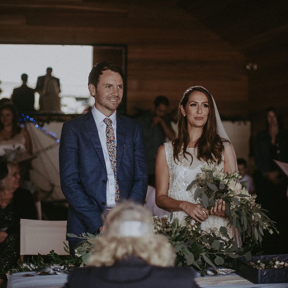 Bride & groom stand at the altar during wedding day on the beach