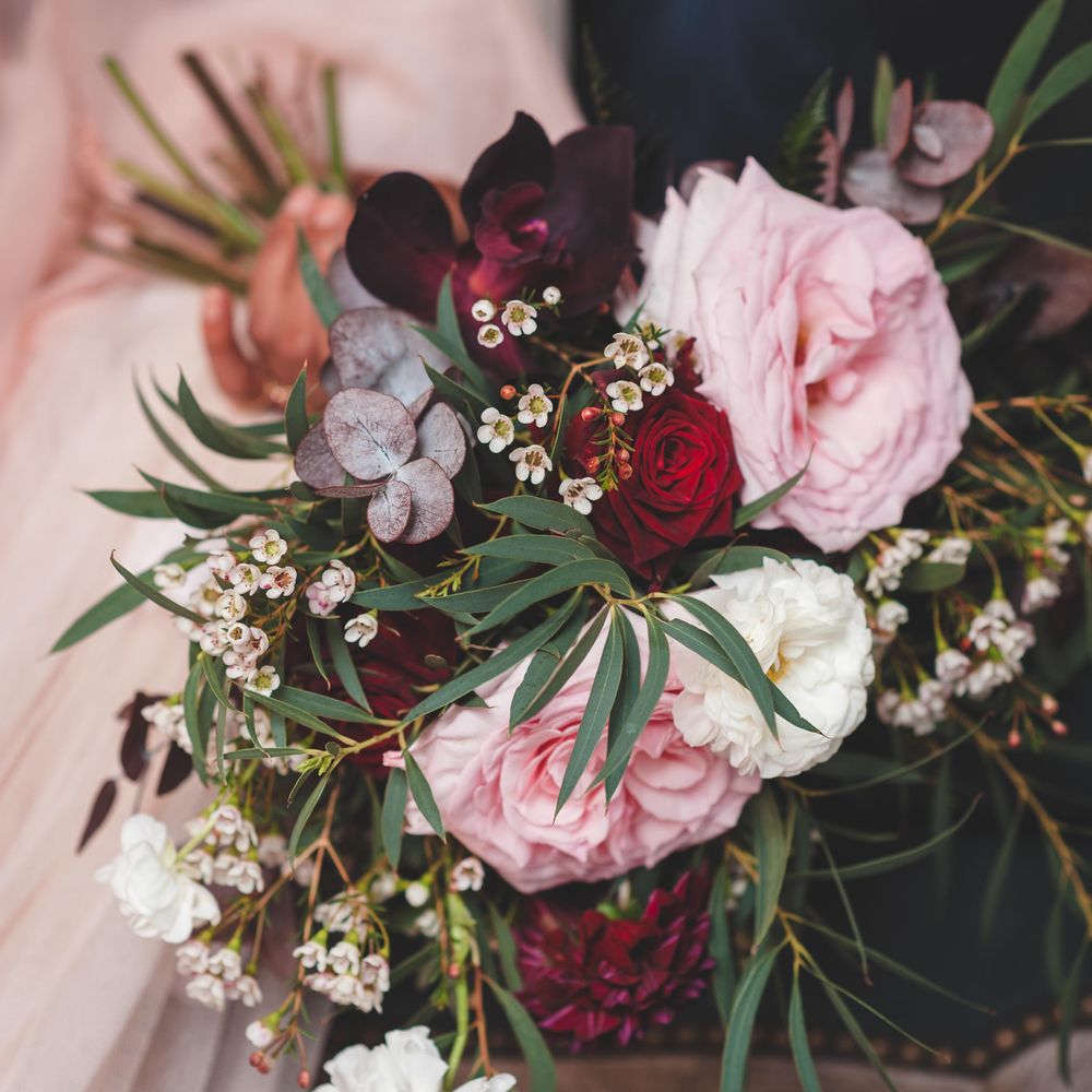 Deep red, pink and white rose wedding bouquet with green foliage 