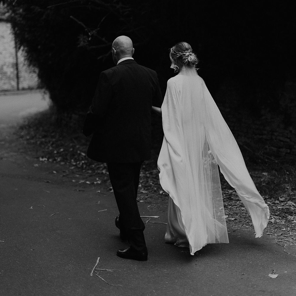 Bride & groom walk together outdoors on their wedding day
