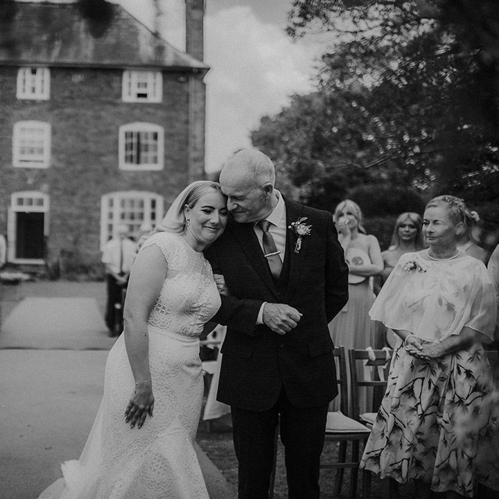 Father of the bride giving his daughter away at an outdoor wedding ceremony at Dewsall Court 