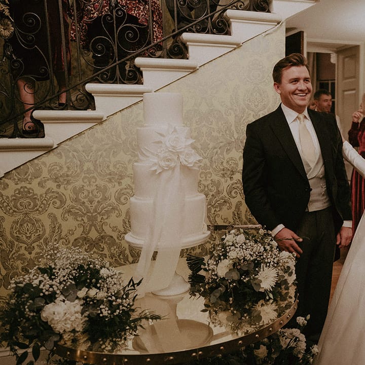 Bride and groom with semi naked white wedding cake at Hedsor House wedding
