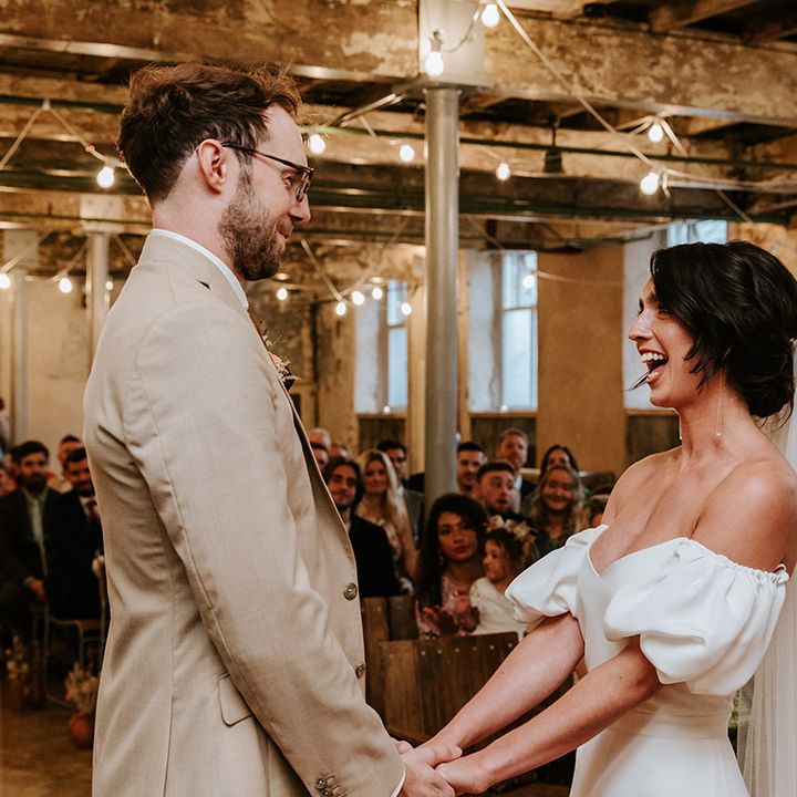 Bride in sweetheart puff sleeve Alexandra Grecco dress and groom in beige three piece suit 