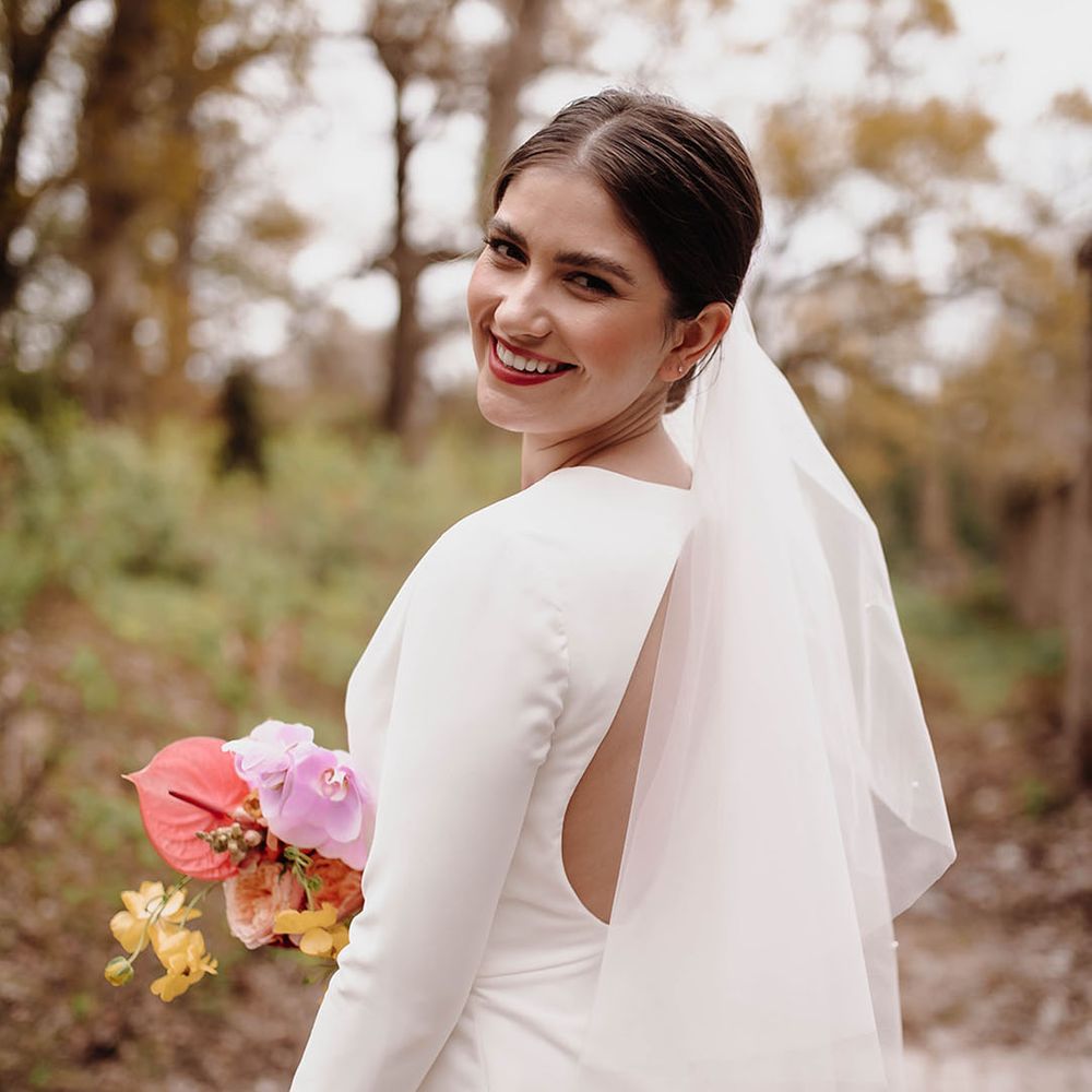 Bride in a short wedding dress with long sleeves and open back detail