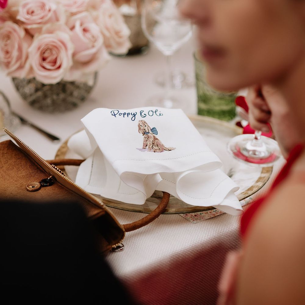 White embroidered napkins with picture of dog and couple names  