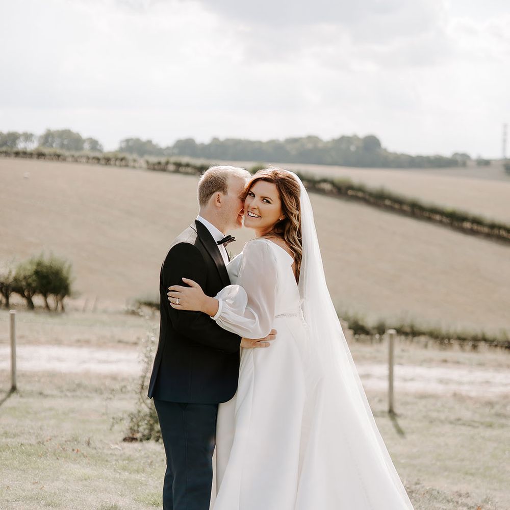 Bride & groom embrace outdoors in fields for couples portraits 