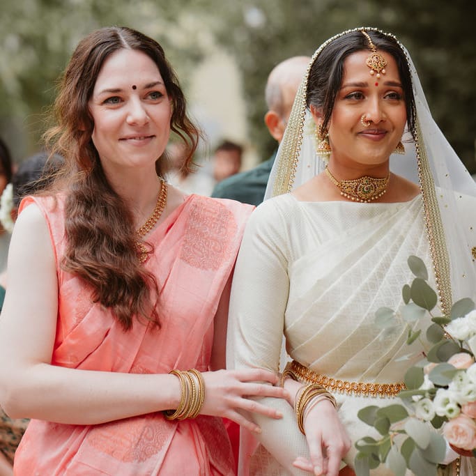 South Asian bride in a cream Lehenga walking down the aisle 