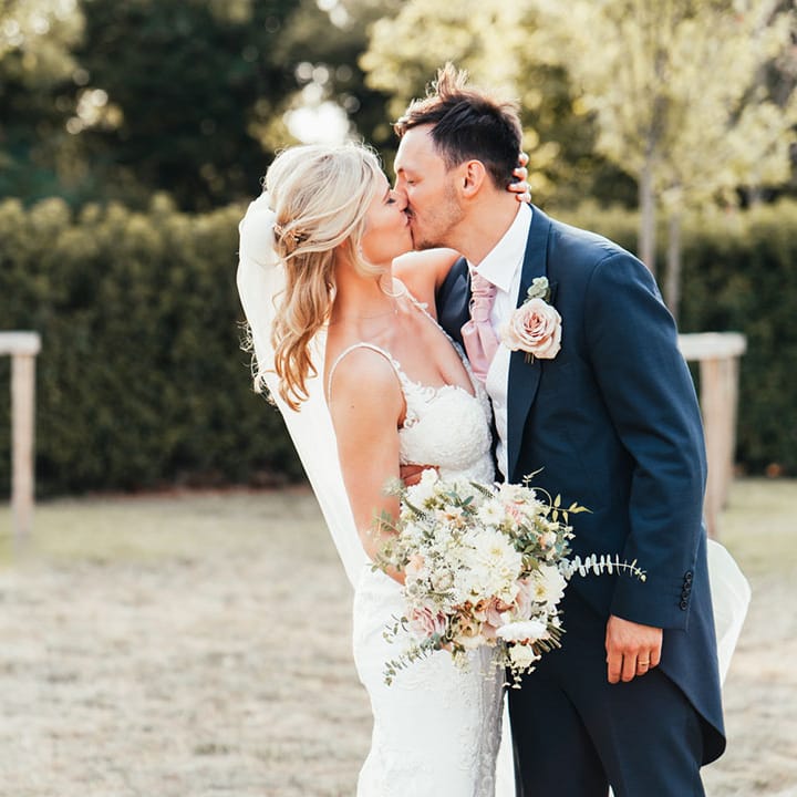 The bride and groom share a kiss together for their couple portraits 