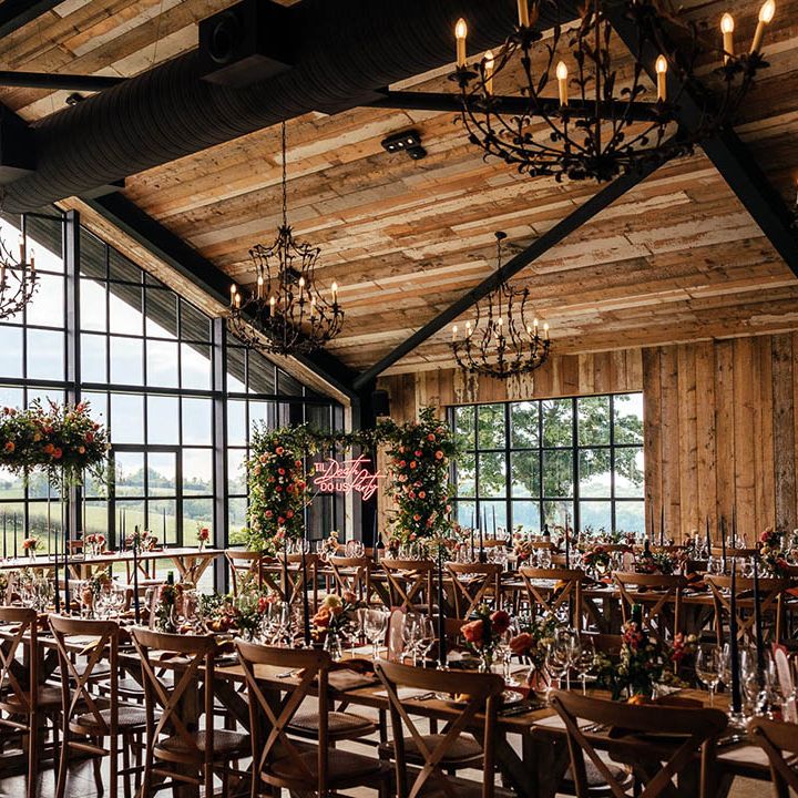 The Barn at Botley Hill wedding venue with iconic windows with blue and copper theme with flower columns, neon sign and disco balls 