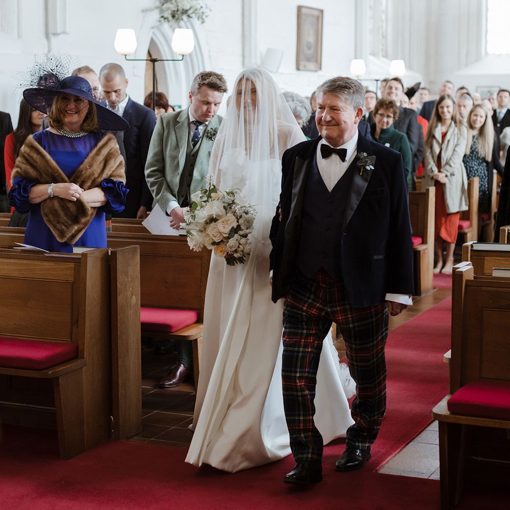 Father of the bride in tartan trousers walking down the aisle with bride in Jessica Bennett wedding dress