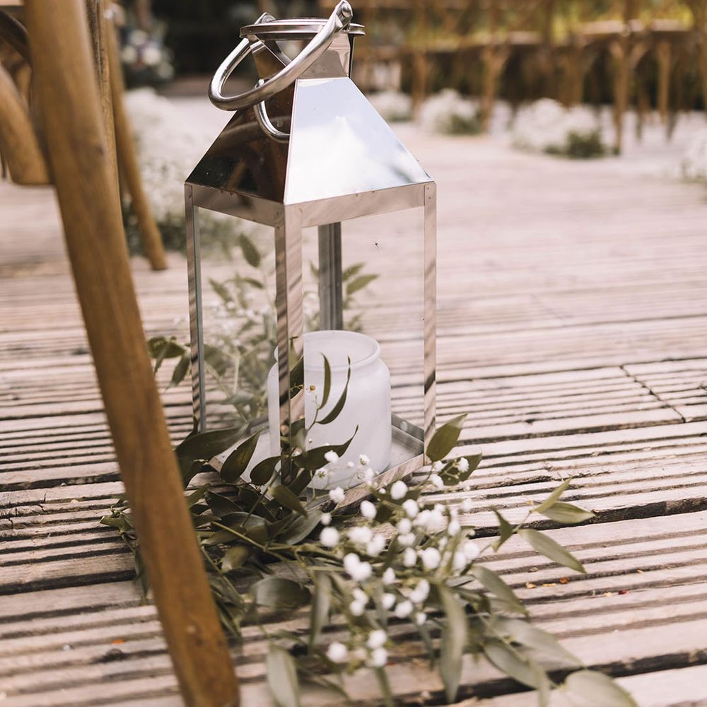 Silver lantern aisle decor with white flowers and foliage 