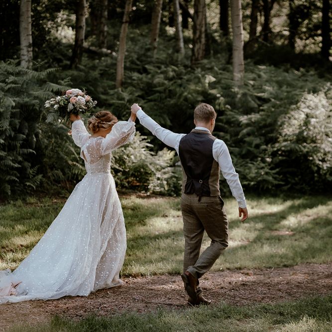 Bride and groom walking through Sherwood Glade wedding venue 