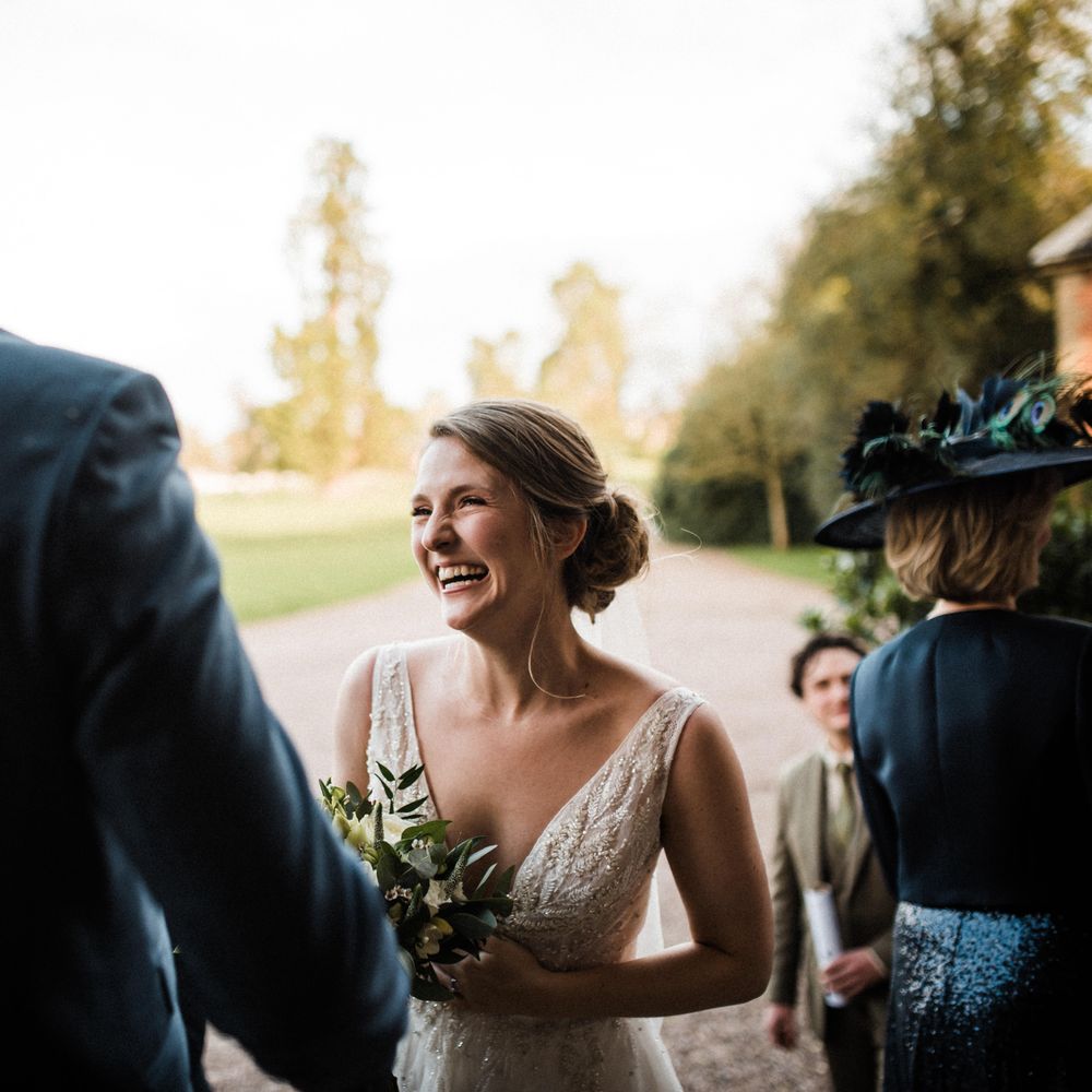 Bride laughs with wedding guests after wedding ceremony