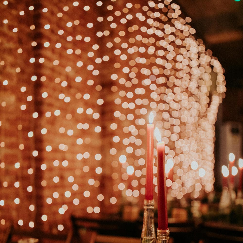 Brown box wedding favours, pine tree centrepieces and a wall of waterfall fairy lights at Block 33