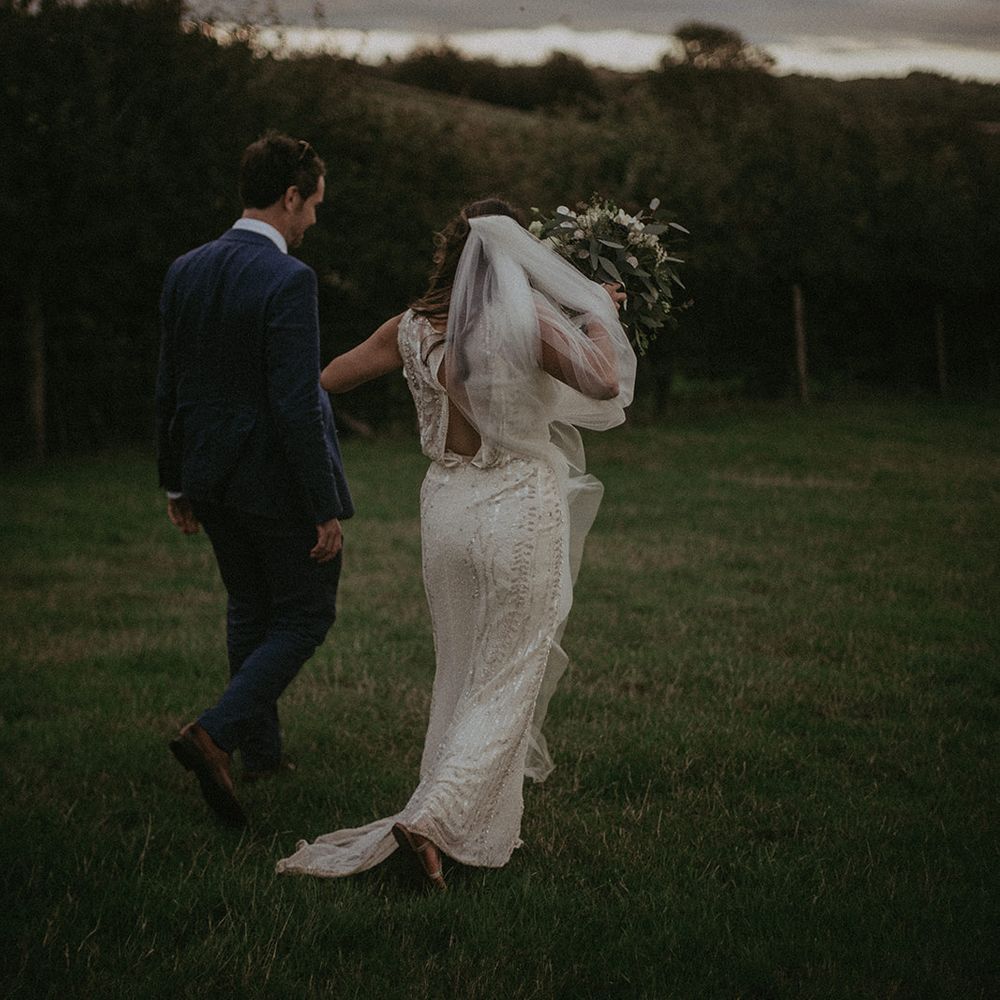 Bride & groom walk together outdoors on their wedding day