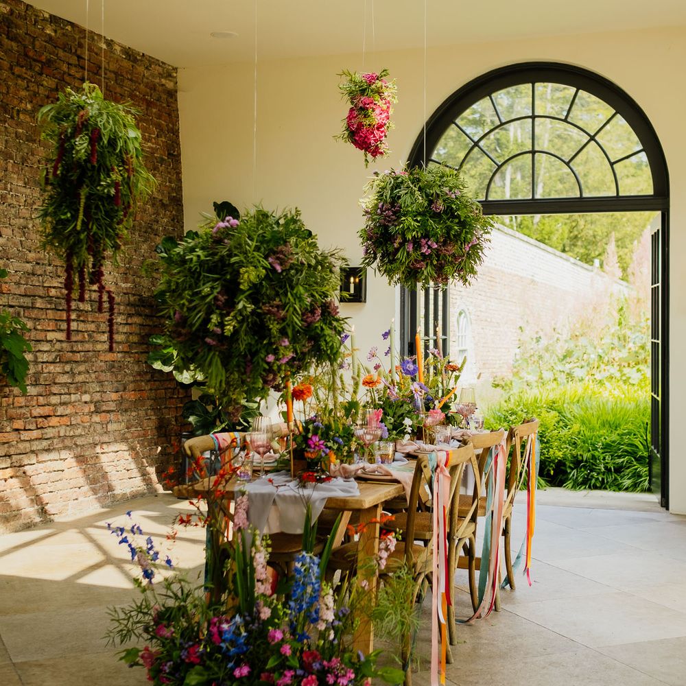 Intimate tablescape at Middleton Lodge Fig House with Hanging installations, flower box centrepieces, ribbon chair backs and taper candles 