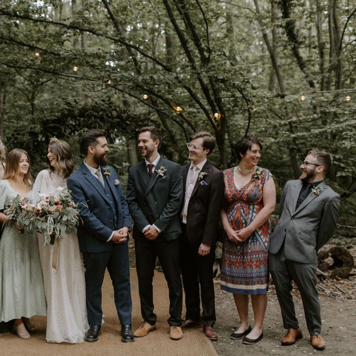 Bride & groom stand with their wedding party on their wedding day outdoors in the woodlands