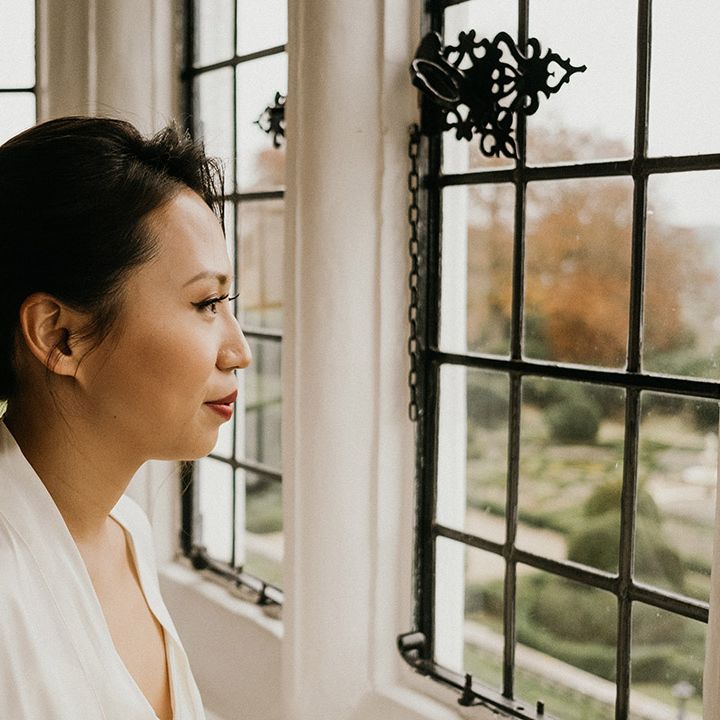 Bride looks out the window of Danesfield House venue