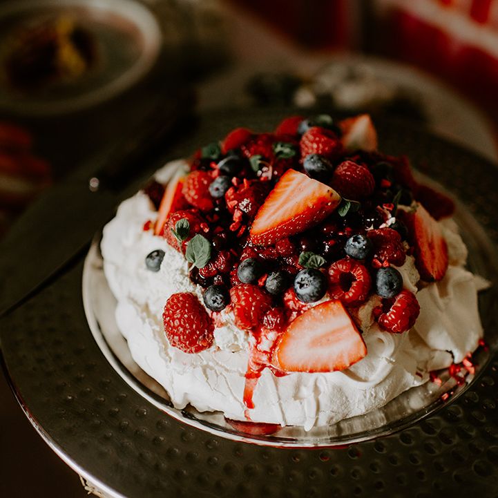 Meringue pavlova topped with straw blue and rasp berries 