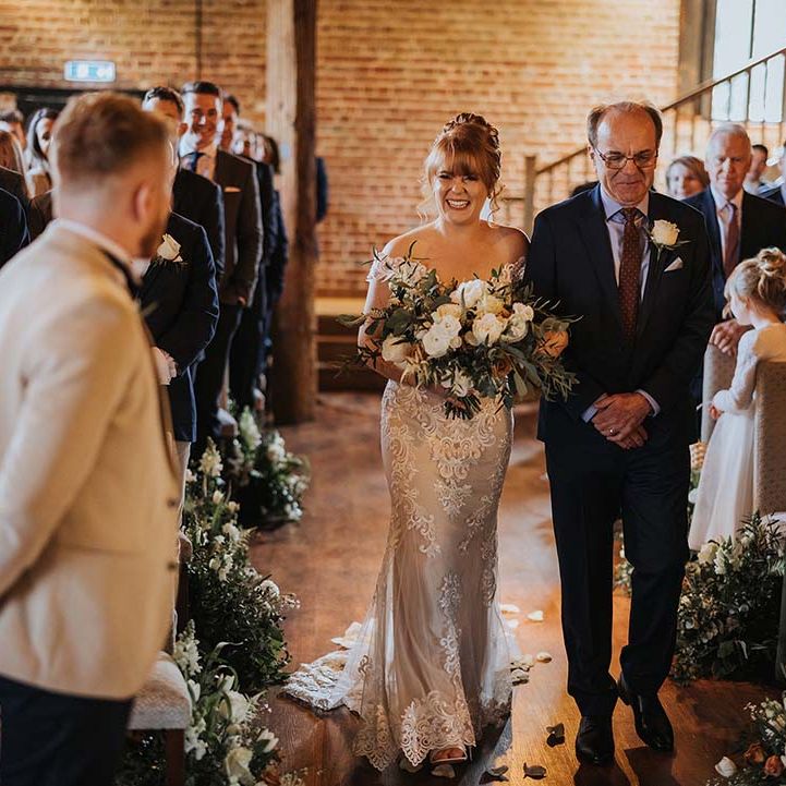 Father of the bride walks the bride down the aisle in barn style wedding at Cooling Castle Barn