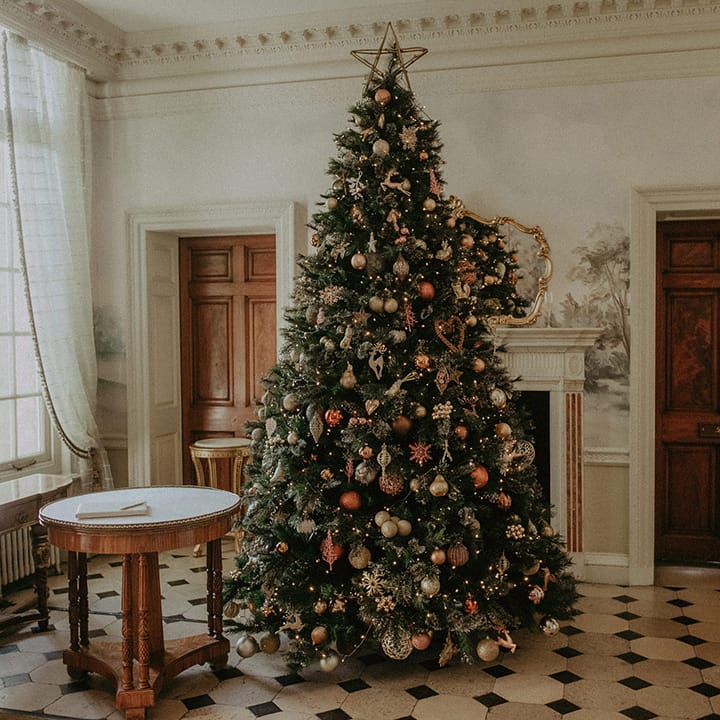 Large Christmas tree with warm toned Christmas decorations at Hedsor House wedding