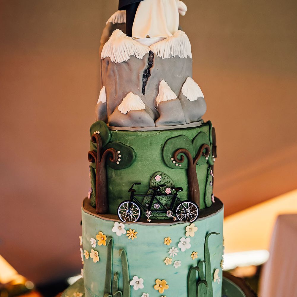 Three tier intricately decorated and colourful wedding cake with personalised bride and groom cake topper 