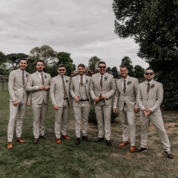 Groomsmen in beige suits with brown shoes and paisley ties 