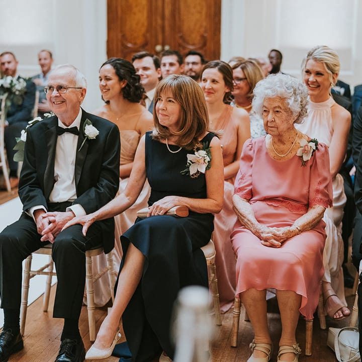 Family members and wedding guests watch the wedding ceremony 
