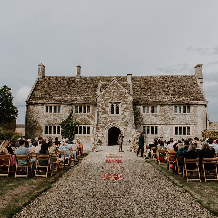 Outdoor wedding ceremony complete with Moroccan styled rugs lining the aisle 