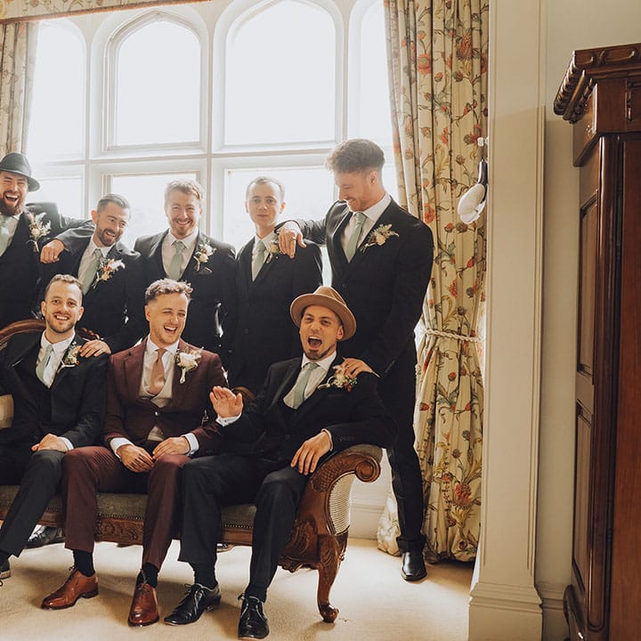 Groom sits with his groomsmen at St Audries Park wedding venue 