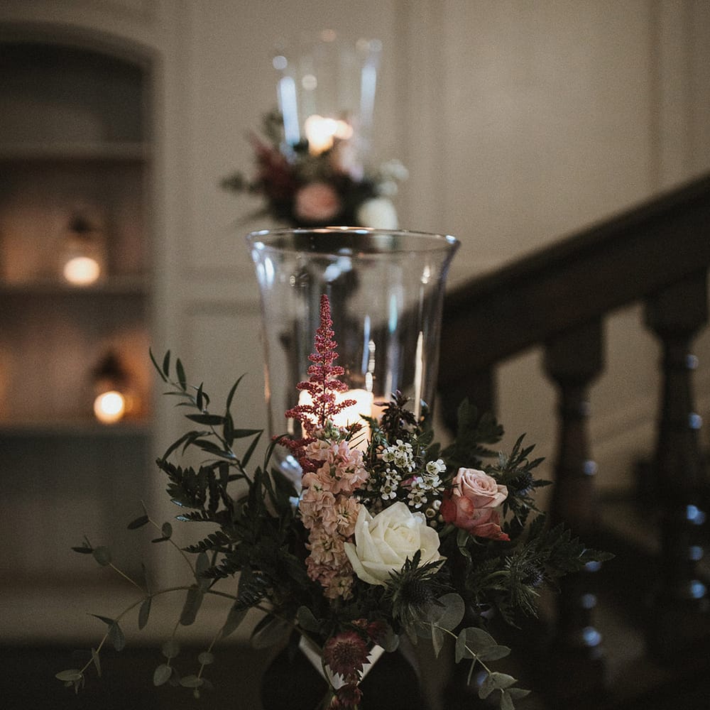 Pink roses and stock with white wax flower, and roses around the lanterns on the stairs 