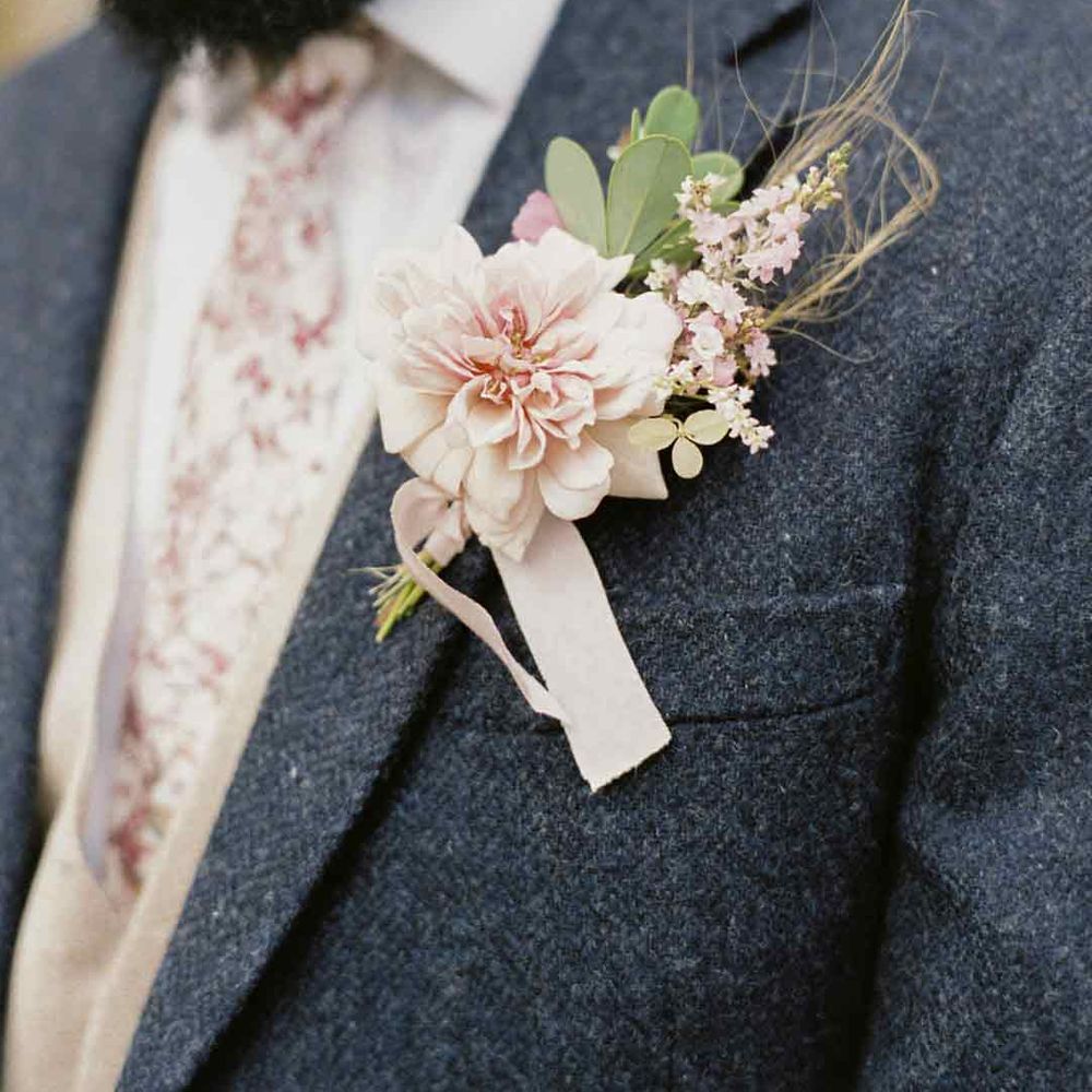 Groom in textured blue wedding suit with white shirt and pink floral wedding tie with light pink peony, baby's-breath and dried flower boutonniere - wedding budget spreadsheet 