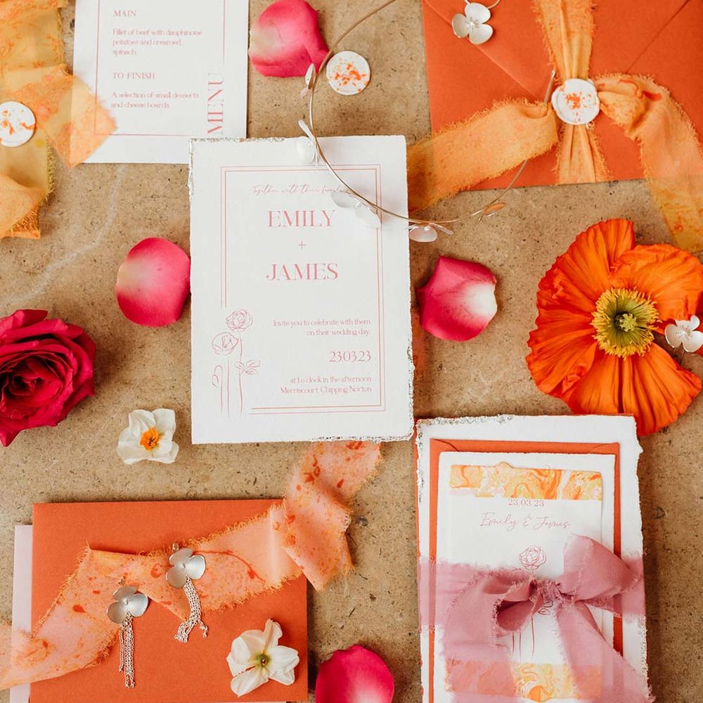 Orange, pink, white and red wedding stationery with frayed ribbon, orange Iceland poppies, dainty silver bridal jewellery and wedding menus 