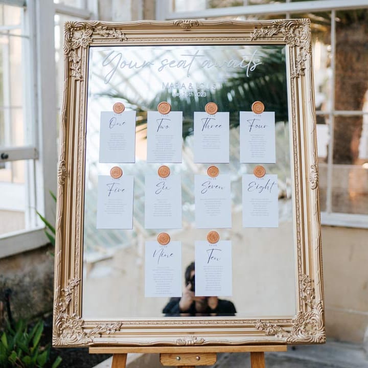 Mirrored wedding seating plan with gold frame and gold wax stickers at Syon Park