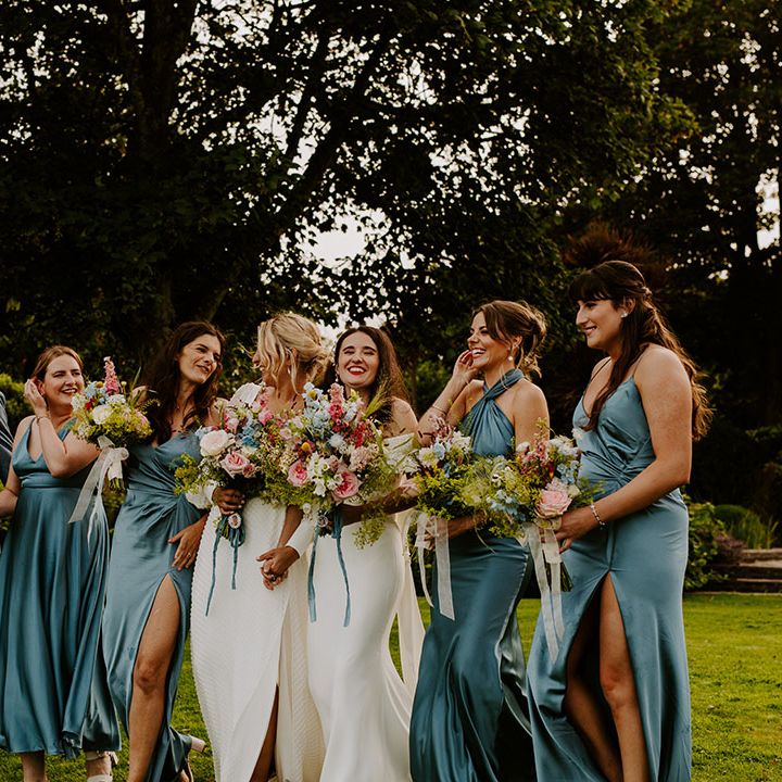 Wedding party wearing blue bridesmaid dresses and a bridesman wearing a blue suit 
