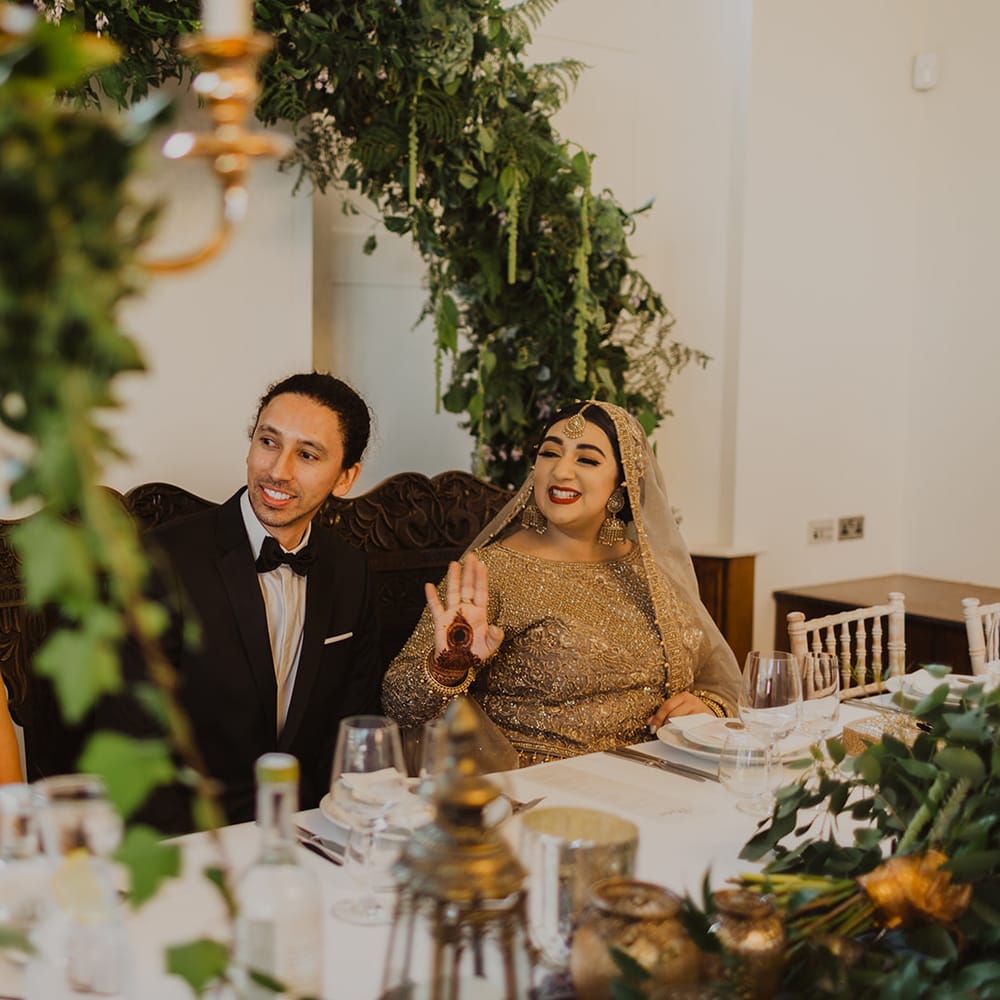 Bride and groom smiling during the wedding reception speeches 