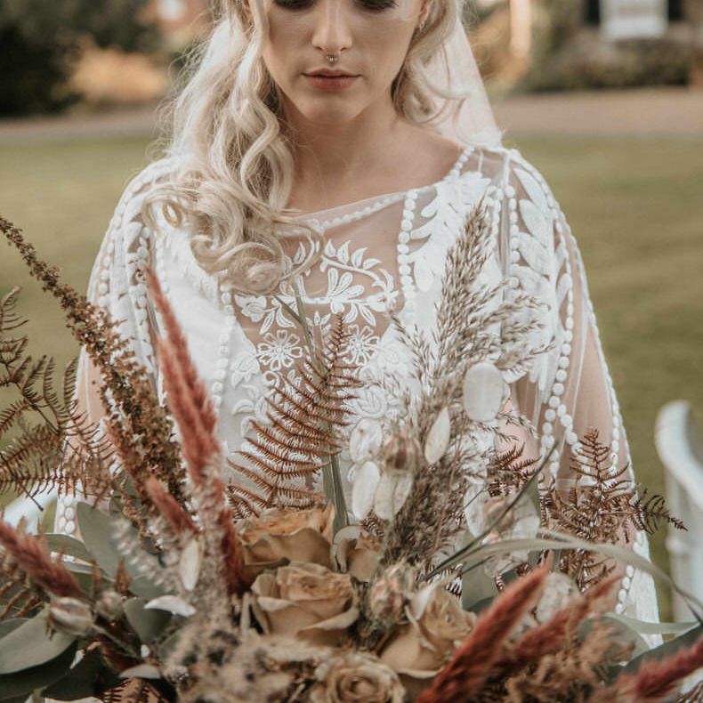 The Bride looks down at her pampas grass bouquet