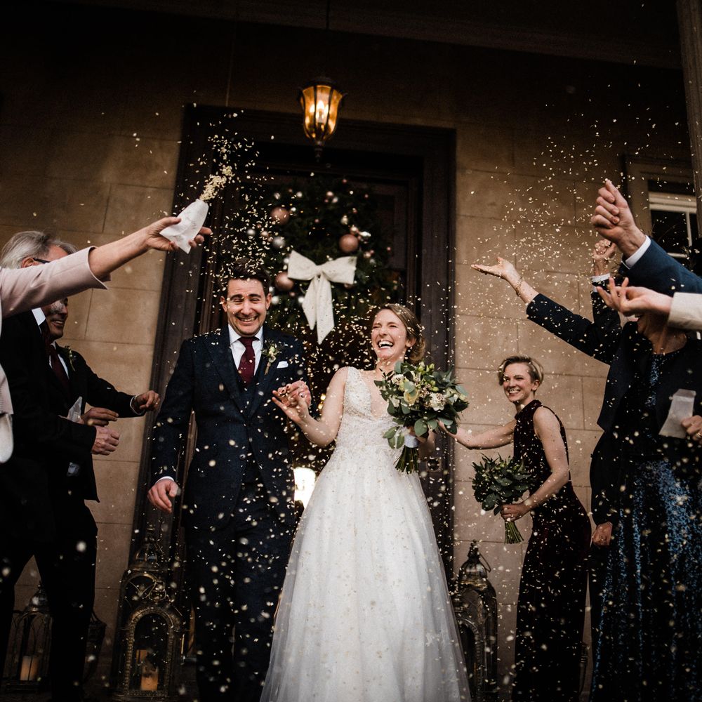 Wedding guests throw confetti outside Davenport House