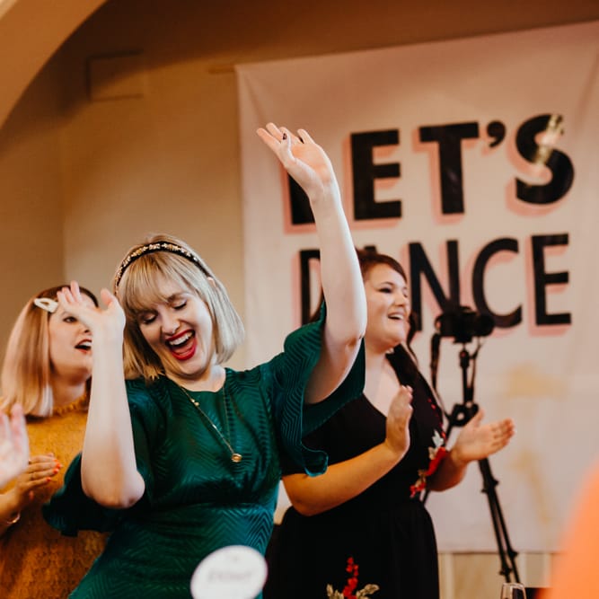 Wedding guest in a dark green dress dancing during the wedding ceremony 