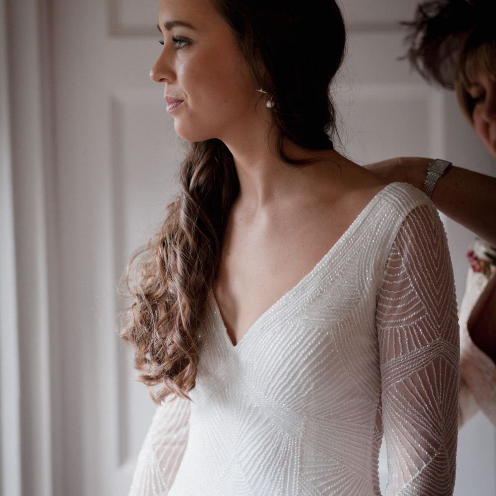 Bride wearing beaded long sleeved, low neck bridal gown