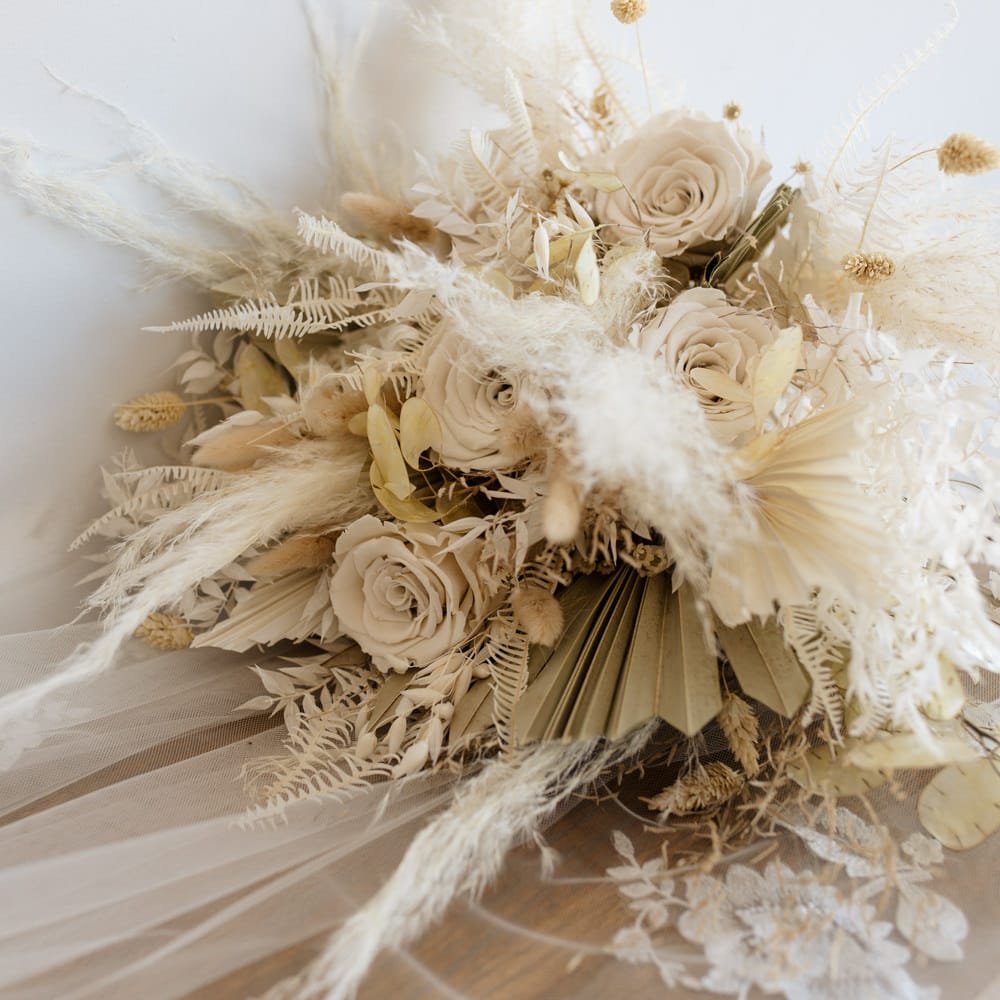 Beige dried flower wedding bouquet with pampas grass, palm leaves and roses 