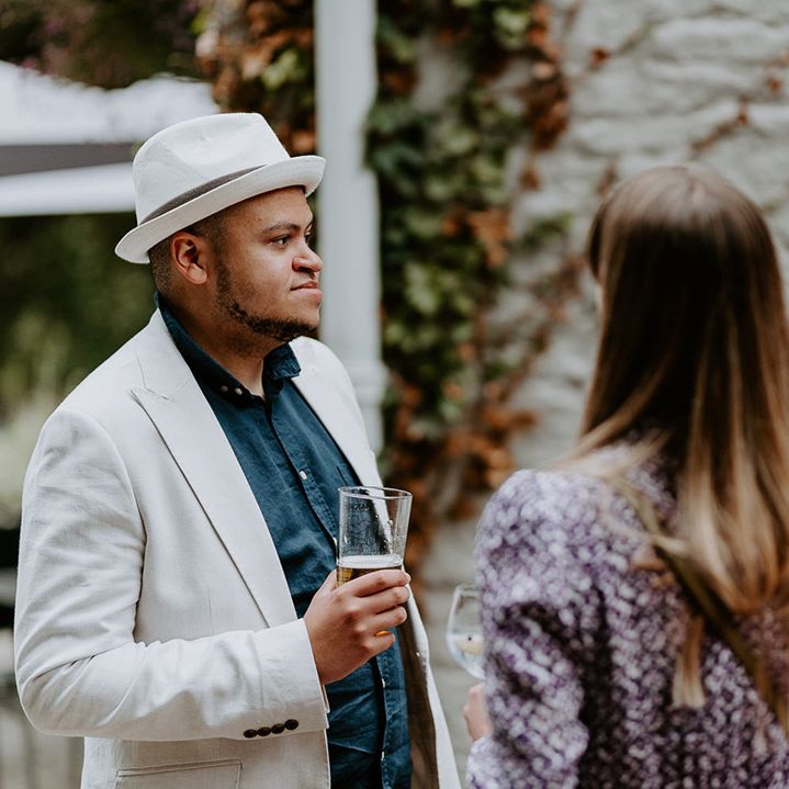 Wedding guests chat outdoors on wedding day