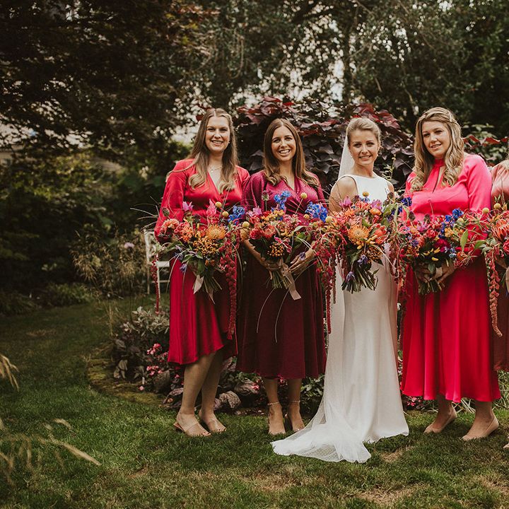 Bridal party in hot pink and magenta pink bridesmaid dresses holding vibrant oversized bouquets 