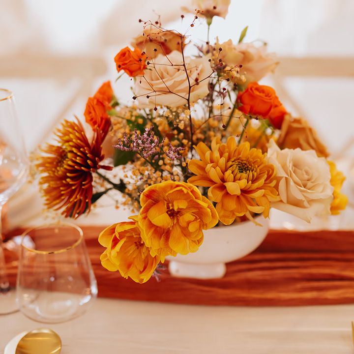 golden blush pink, orange and yellow wedding flower arrangement 